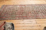 Distressed antique Karabagh runner texture, featuring worn herati motif in muted plum, brown, and ivory.