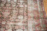 Distressed Karabagh rug's worn pile, exposed foundation, and classic serrated leaf border.