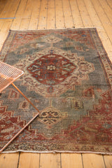 Distressed Northwest Persian rug's central medallion and geometric floral motifs, showing its even wear.