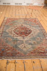 Distressed Northwest Persian rug with concentric medallion and thinly banded border, faded blue and red.