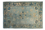 Distressed Antique Chinese Peking rug, powder blue field, ivory and gold floral design, indigo border.