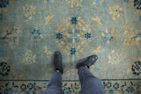 Distressed antique Peking rug featuring worn powder blue field and soft gold floral motifs.