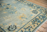 Antique distressed Peking rug with powder blue field, subtle wear, and dusty gold floral border.