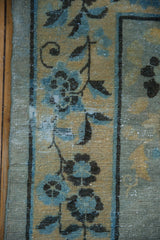 Antique Distressed Peking rug showing powder blue floral patterns, golden field, and worn texture.