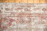 Distressed vintage Mahal runner detail, showcasing faded red and ivory motifs with visible weave.