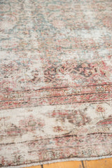 Distressed texture of vintage Mahal runner, showcasing faded pale red and blue Herati motifs on exposed ivory foundation.