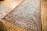 Vintage Mahal runner's worn end, highlighting muted blush tones, faded Herati pattern, and subtle fringe.