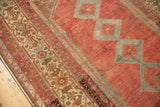 Distressed vintage Malayer rug: intricate ivory border, low pile cranberry red field with blue patterns.
