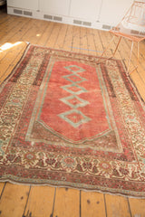 The distressed low pile of the Malayer rug's ivory floral border and secured fringe.