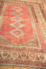 Distressed low pile of a vintage Malayer rug, with detailed ivory and cranberry border.