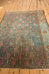 Distressed Malayer rug field with intricate blue, red, and gold paisley boteh motifs.