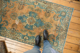Vintage distressed Tabriz rug with faded camel and powder blue floral patterns.