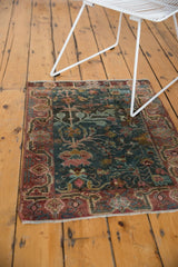 Distressed Sarouk rug corner showing low pile, faded cranberry border, and blue field with palmettes.