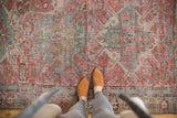 Distressed antique Caucasian Soumac rug featuring geometric designs in blush red and slate blue.