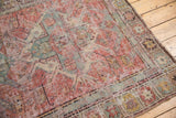 Distressed geometric pattern in dusty red, pale gold, and slate blue on antique Soumac rug.
