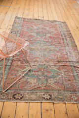 Distressed antique Caucasian Soumac rug showcasing geometric medallion in faded blush red and slate blue.