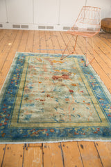 Distressed blue cloudband border and worn pictorial field of an antique Peking rug.