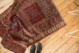 Hand-knotted geometric patterns in chestnut, navy, and terracotta with rams horn motif.