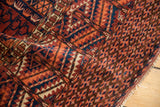 Vintage Turkmen rug detail: fringed end, geometric rams horn border, and serrated leaf patterns.