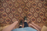 Antique Beshir carpet's intricate germinating plant pattern in aubergine, terracotta, navy.