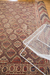 Antique Beshir carpet panel motif, germinating plants in terracotta, aubergine, and navy tones.