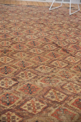Intricate germinating plant lattice in terracotta, dusty aubergine brown, navy, with mostly even wear.