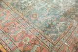 Distressed Mahal rug corner, pale teal and terra cotta geometric patterns, showing even wear.