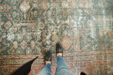 Distressed Mahal carpet, allover geometric pattern showing muted teal and terra cotta tones.