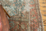 Distressed vintage Mahal carpet corner, showing geometric patterns, pale dusty teal, and terra cotta.