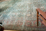 Distressed Mahal rug border featuring pale terra cotta blush and dusty teal geometric motifs.
