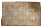 10x16 distressed Kerman carpet, allover millefleur design in muted blue, ivory, and terracotta.