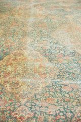 Muted blue, red, ivory millefleur pattern on distressed vintage Kerman carpet pile.