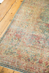 Distressed Kerman corner, intricate millefleur design, worn pile, and visible foundation.