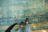 Distressed sky blue and gold floral motifs on an antique Chinese Peking carpet.