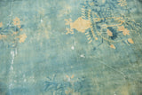 Artfully faded sky blue field, revealing pale gold vase and floral sprays on an antique Peking rug.