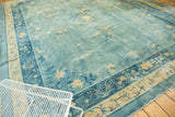 Soothing distressed sky blue field and intricate floral borders on an antique Peking carpet.