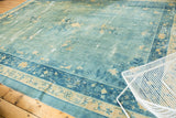 Distressed sky blue field and intricate floral border of an antique Peking carpet.