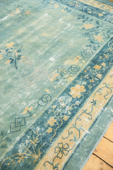 Distressed sky blue field, pale gold floral motifs, and patterned borders of antique Peking carpet.