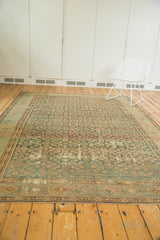 Angled view of the distressed Malayer carpet, showing its aged herati pattern and softened pile.