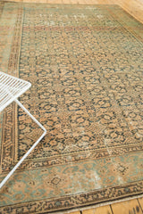 Distressed vintage Malayer rug; faded navy and brown Herati pattern with abrashes.