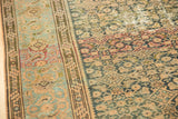 Distressed vintage Malayer rug showing worn Herati pattern, exposed foundation, and border.