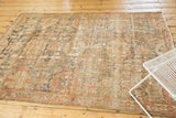 Distressed Malayer rug featuring allover roundel medallions in muted teal, ivory, and terra cotta.