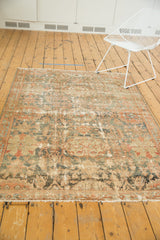 Distressed Malayer rug with secured fringe, showcasing muted charcoal teal border details.