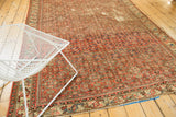 Fragmented vintage Hamadan rug showing red herati motif field and localized foundation wear.
