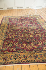 Vintage Lilihan carpet corner with detailed floral vinery, rich colors, and light tatter.