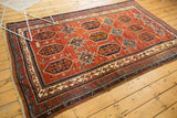 Geometric border design of a vintage Caucasian Kazak rug in madder red, blue, and ivory.