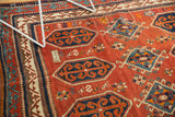 Madder root red field and geometric blue motifs on a vintage Caucasian Kazak rug.