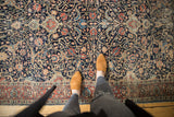Ornate navy field and red border of antique Tabriz rug with scrolling arabesques and palmettes.
