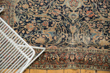 Antique Tabriz rug: intricate navy, beige field, scrolling palmettes, and terracotta border.