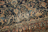 Antique Tabriz rug with dark navy, beige, terracotta arabesques, palmettes, and visible foundation wear.